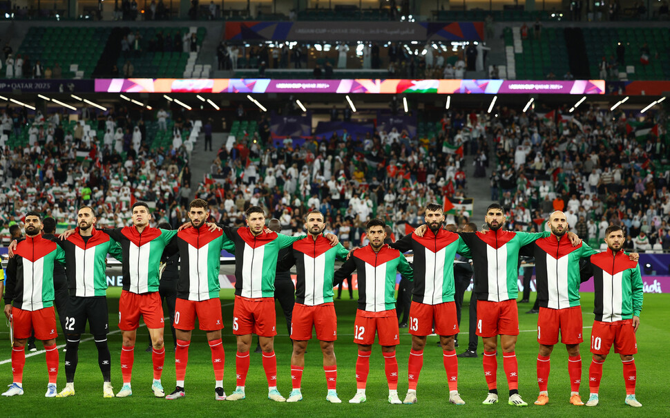 1월14일 이란과 겨룬 아시안컵 첫 경기 식전 공식 행사에서 국가가 연주되자 팔레스타인 대표팀 선수들이 서로 어깨를 겯고 결의를 다지고 있다.