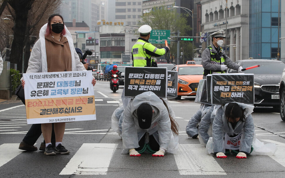 South Korean college students hold a “three steps, one bow” march Sunday from Gyeongbokgung Station to the Blue House to demand tuition refunds. (Park Jong-shik/The Hankyoreh)