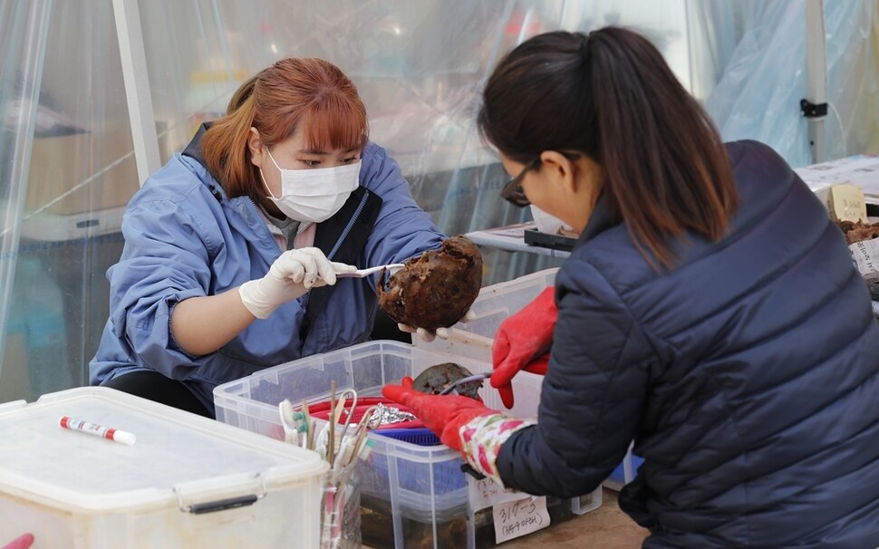 홍수정 발굴단 상황실장(오른쪽)과 단원들이 발굴된 유해를 아세톤으로 세척하고 있다.