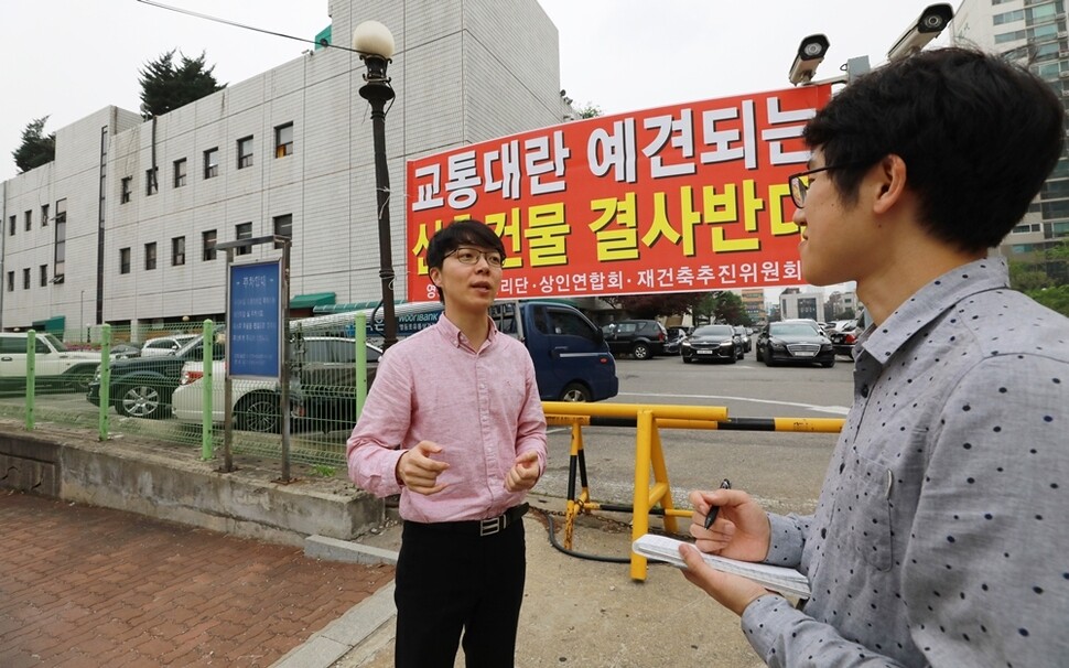 서울 영등포구 당산2가 청년임대주택 터에 걸린 ‘결사반대’ 펼침막 앞에서 우인철 ‘우리미래’ 서울시장 예비후보(왼쪽)가 기자에게 말하고 있다.