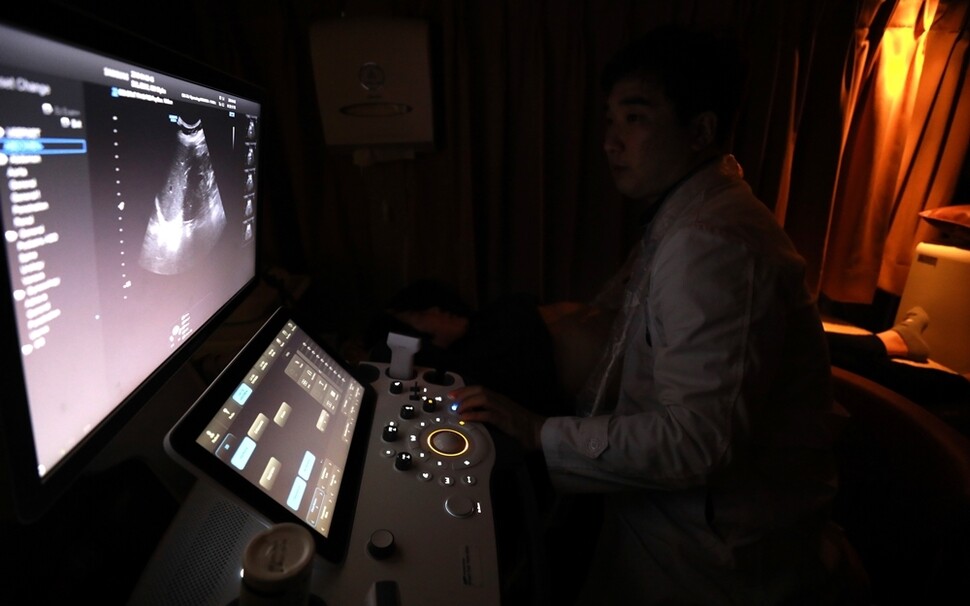 행복버스 안에 설치된 의료장비로 초음파 검사를 받는 ‘하고자 마을’ 주민.