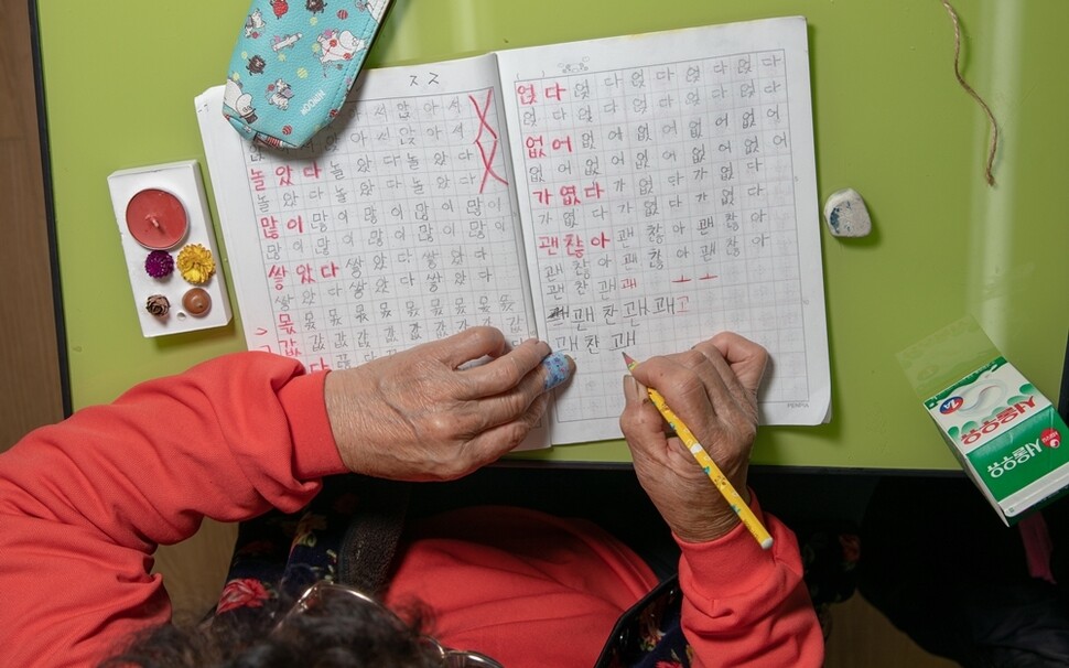 전일옥 할머니가 공책에 연필로 한글을 쓰고 있다. 카메라 때문에 긴장해 평소보다 글자가 커져버렸다.