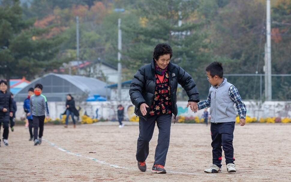 전일옥 할머니가 같은 반 김형우 어린이와 아침 건강달리기를 하려고 손을 잡는다.