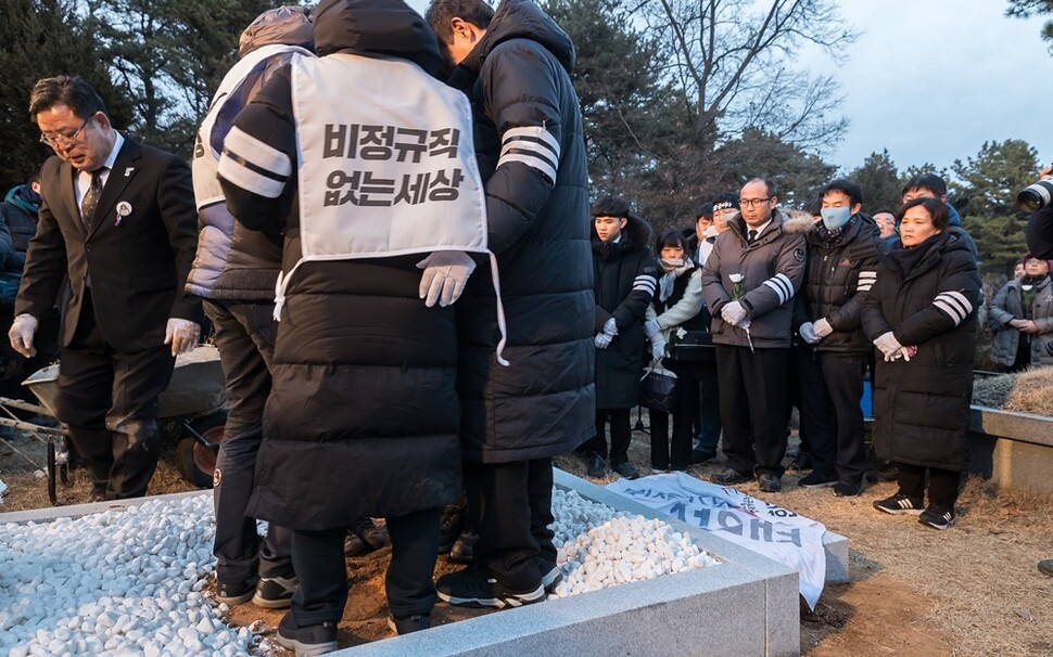 고 김용균씨 동료들이 김씨가 묻힌 묘소에 올라 흙을 다지고 있다.
