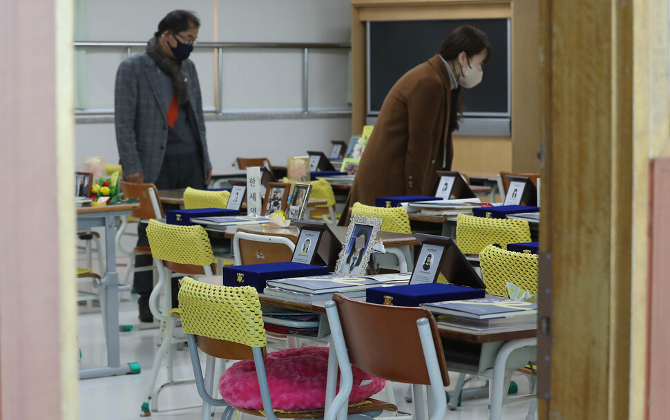 기억패 수여식이 끝난 뒤 관계자들이 교실 책상에 놓인 기억패를 살펴보고 있다. 안산/신소영 기자