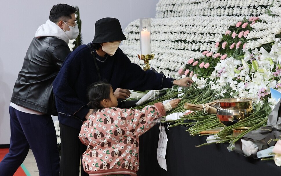 People place flowers on an altar for the victims of the Itaewon crowd crush located in Seoul Plaza on Oct. 31. (Yonhap)