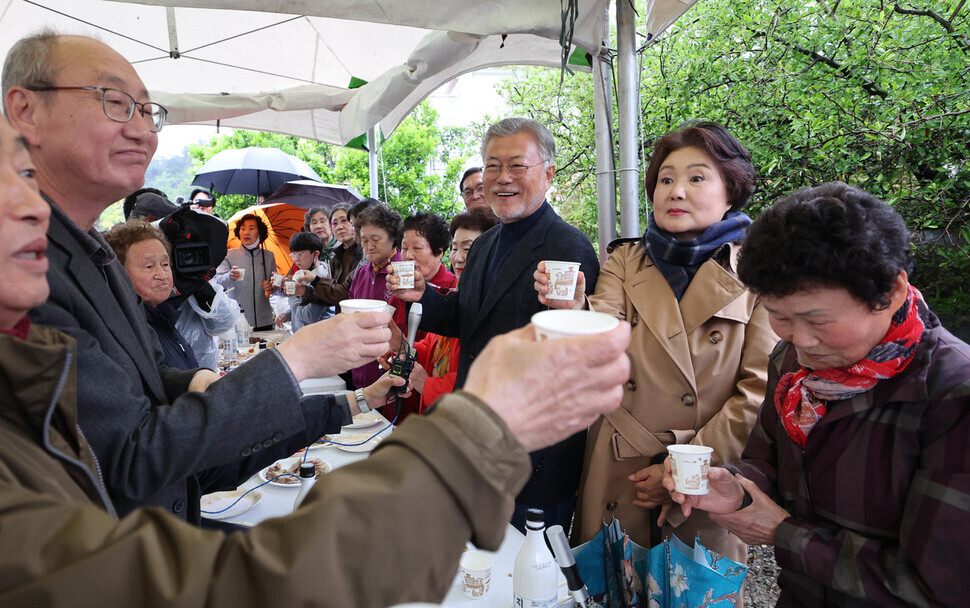 Moon and his wife Kim Jung-sook toast cups of makgeolli, a rice wine, with local residents after the signboard-hanging ceremony at the former president’s bookshop in Pyeongsan, a village in the South Gyeongsang Province city of Yangsan on April 25. (Baek So-ah/The Hankyoreh)