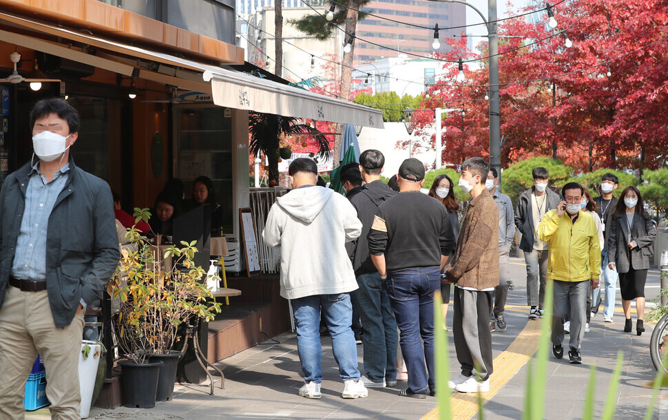 Diners wait for tables to open up outside the restaurant. (Shin So-young/The Hankyoreh)