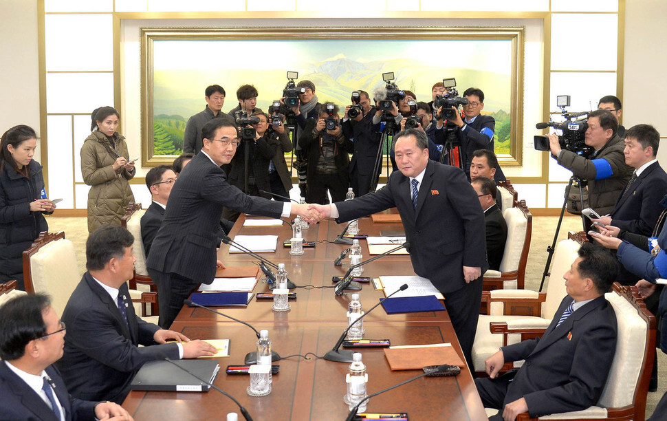 South Korean Minister of Unification Cho Myoung-gyon (left) shakes hands with Ri Sonn-gwon