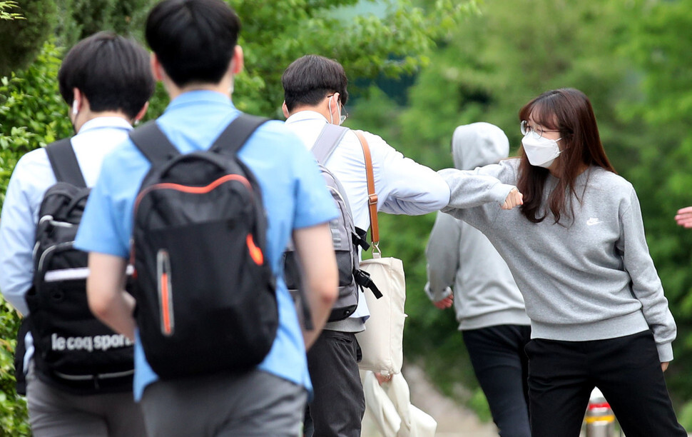 Seniors at Kyungbock High School in Seoul greet each other by bumping elbows on the morning of May 20. (Baek So-ah, staff photographer)
