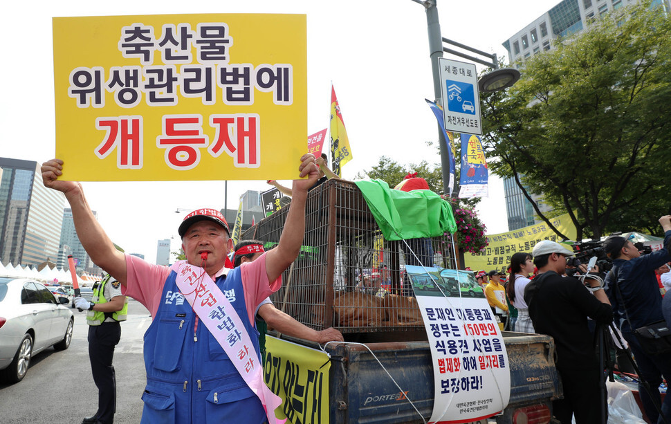 About 250 members of the Korean Dog Farmers Association staged a large demonstration on Sept. 22 demanding that their industry be legally recognized and regulated like other livestock sectors. The association members are also protesting a bill offered in the National Assembly by Minjoo Party lawmaker Pyo Chang-won that would ban the consumption of dog meat. The farmers gathered in Jong-no with nine caged dogs and then marched toward the Blue House.  (Kim Jeong-hyo