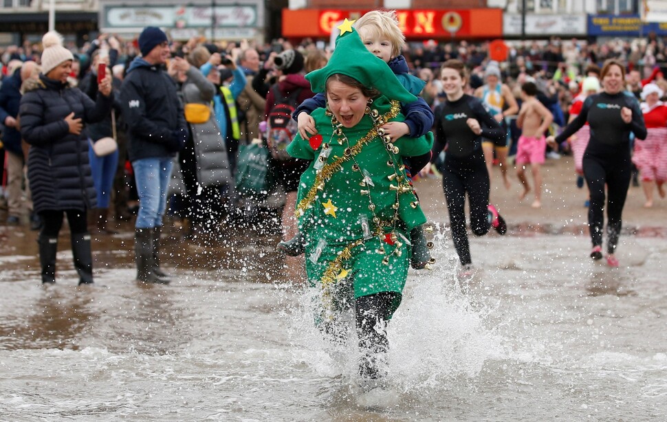 영국 스카버러 해변에서 새해맞이 행사에 참여한 시민들이 바다로 뛰어들고 있다.