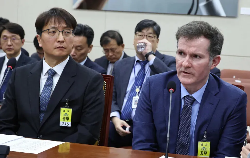 Coupang CEO Park Dae-jun glances at Coupang Chief Information Security Officer Brett Matthes as he responds to questions from lawmakers on the National Assembly Science, ICT, Broadcasting and Communications Committee at the National Assembly in Yeouido, Seoul, on Dec. 2, 2025. (Yoon Woon-sik/Hankyoreh)