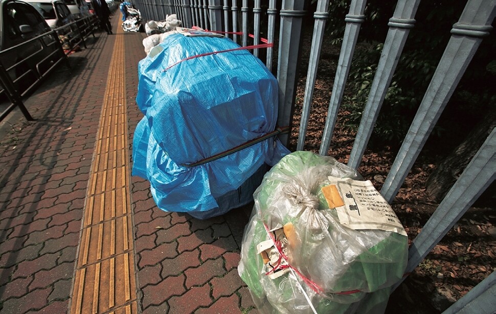 우에노공원에 출입 금지당한 노숙인들의 짐꾸러미가 공원 옆 인도에 줄지어 놓여 있다.