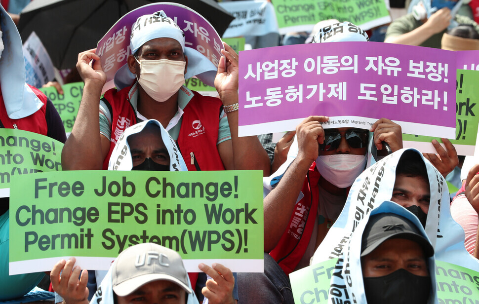 Migrant workers hold up signs at a national rally for migrant workers held outside Yongsan Station in Seoul on Aug. 20. (Kang Chang-kwang/The Hankyoreh)