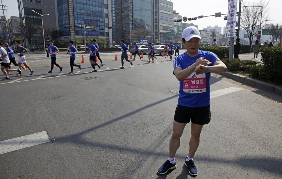 서울국제마라톤 10km 부문에 참가한 남경필 경기도지사가 5km 지점에서 레이스를 멈추고 기록을 확인하고 있다. 완주를 목표로 달리던 남 지사는 갑작스럽게 생긴 일정 때문에 코스 절반을 달리는 데 만족해야 했다.   
