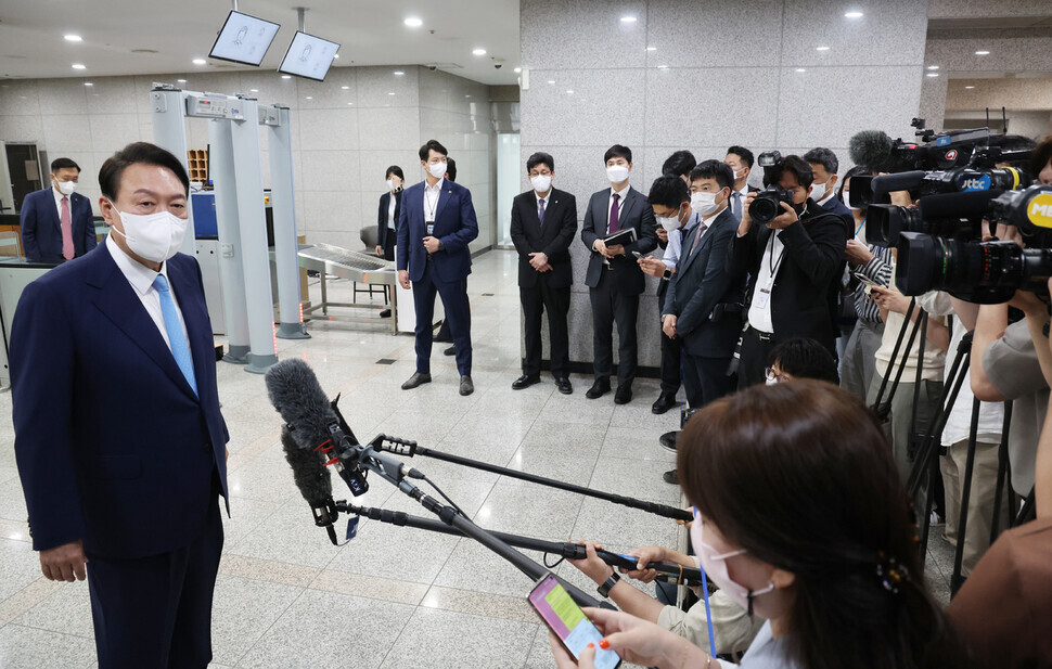 President Yoon Suk-yeol answers questions from the press as he enters his office in Yongsan on June 14. (Yonhap News)