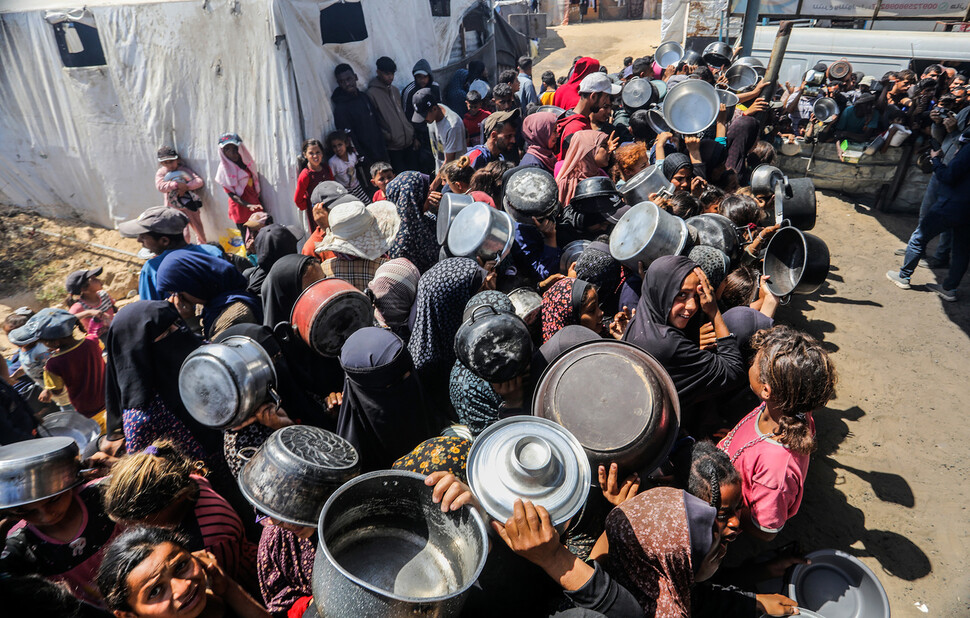 2025년 4월29일 팔레스타인 땅 가자지구 남부 칸유니스에서 피란민들이 음식 배급을 받기 위해 무료 급식소 앞에 늘어서 있다. UPI 연합뉴스