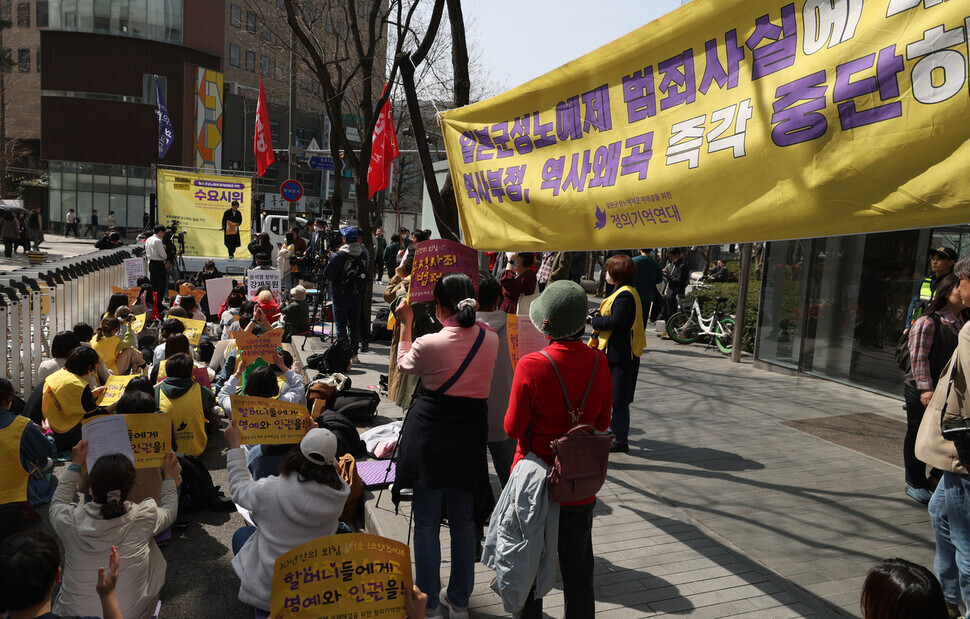 Participants at the 1,588th Wednesday Demonstration on March 22 hold up signs demanding a formal apology and legal reparations from Japan. (Kang Chang-kwang/The Hankyoreh)