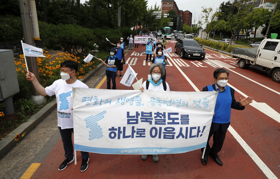 Marchers walk from Yeokgok Station in Bucheon, Gyeonggi Province, to Cheonwang Station in Seoul on Monday while holding a banner reading, “Let’s connect the railways of South and North Korea.” (Kim Hye-yun/The Hankyoreh)
