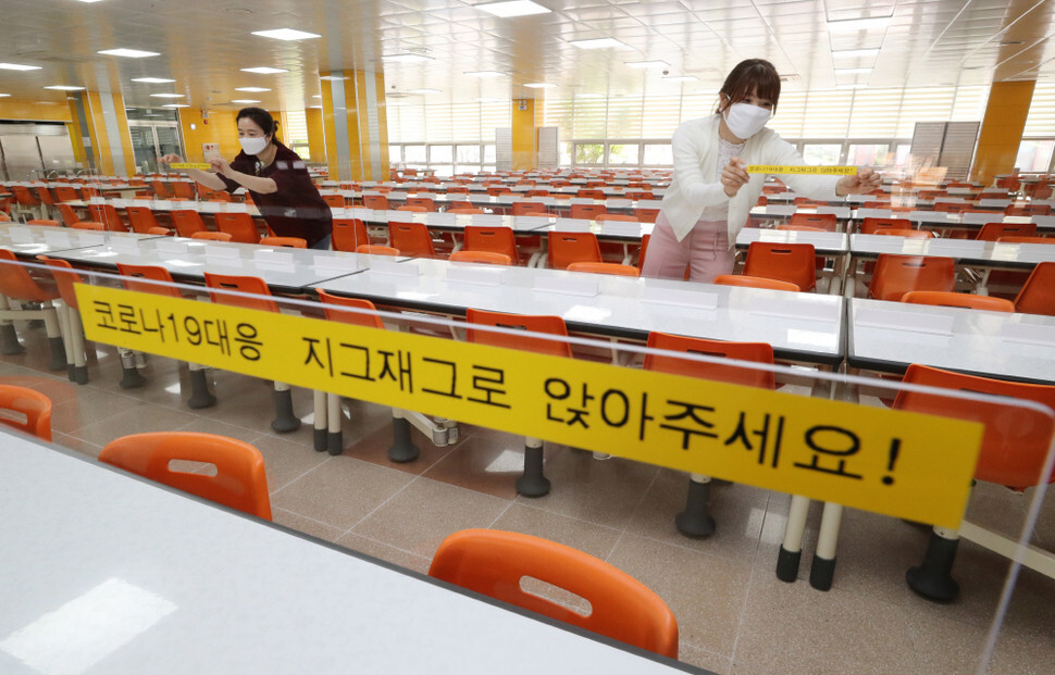 A high school in Sejong City prepares to reopen its campus for classes by installing transparent barriers on desks on May 1. (Yonhap News)