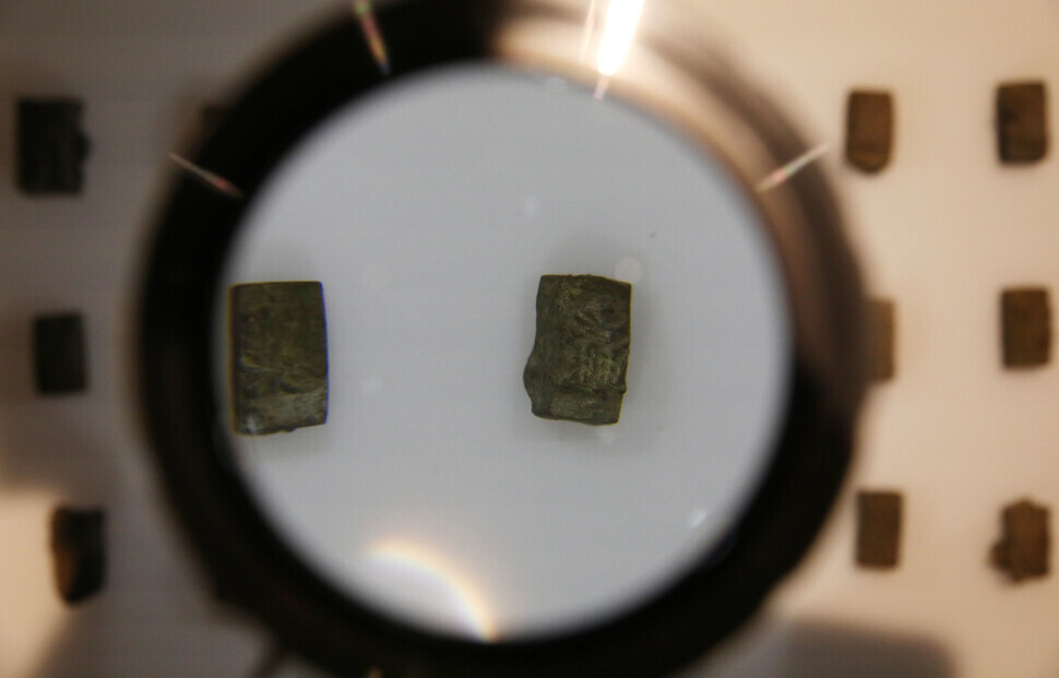 Pieces of movable type still requiring research on the period of production are on display on the first floor of the National Palace Museum of Korea in Seoul’s Jongo District on Tuesday, one day ahead of a public exhibition on the relics excavated in Insadong. Magnifying glasses are available throughout the gallery to allow a closer view of the metal type pieces on display. (Kim Hye-yun/The Hankyoreh)