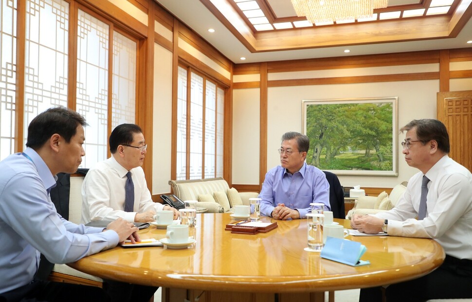President Moon Jae-in listens to Blue House National Security Office director Chung Eui-yong describe the results of his visit to the US to meet President Donald Trump along with National Intelligence Service director Suh Hoon (right) at a meeting room in the Blue House on Mar. 11. (provided by Blue House)