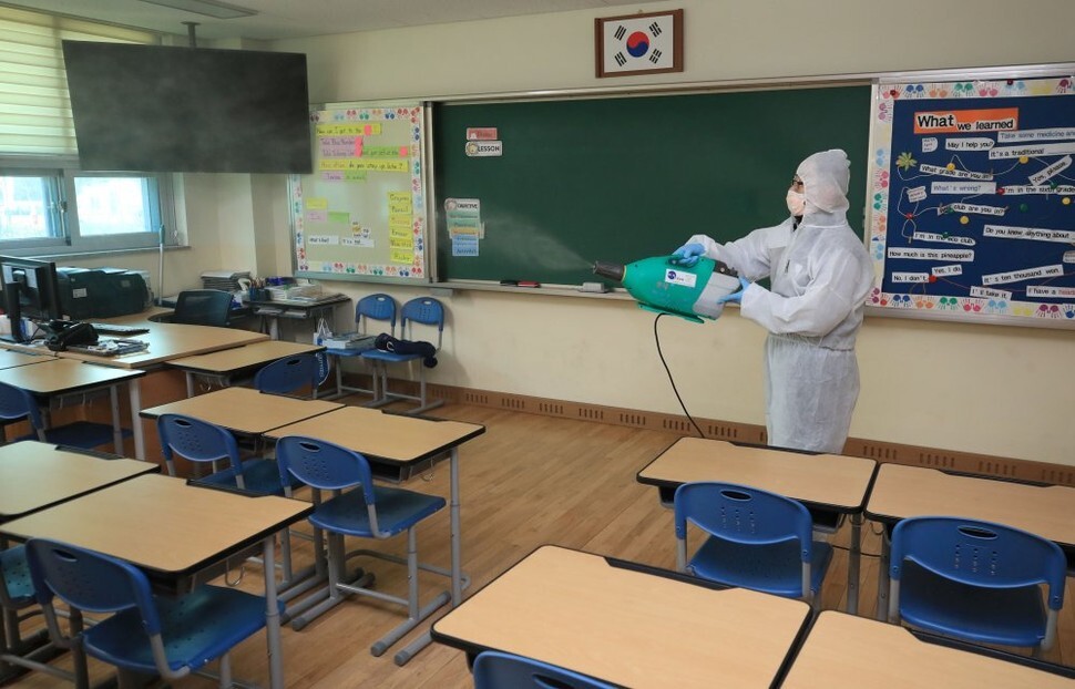 A sanitation worker disinfects a classroom at an elementary school near an apartment complex in Seoul’s Songpa District where a confirmed novel coronavirus patient resides on Mar. 7. (Yonhap News)