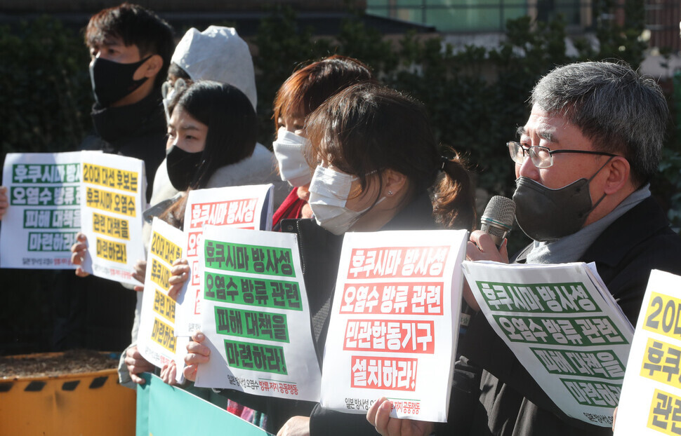 Members of environmental groups present at the press conference hold up signs as they urge candidates for president to announce their stances on Japan’s plans to release radioactive water into the ocean. (Kim Tae-hyeong/The Hankyoreh)