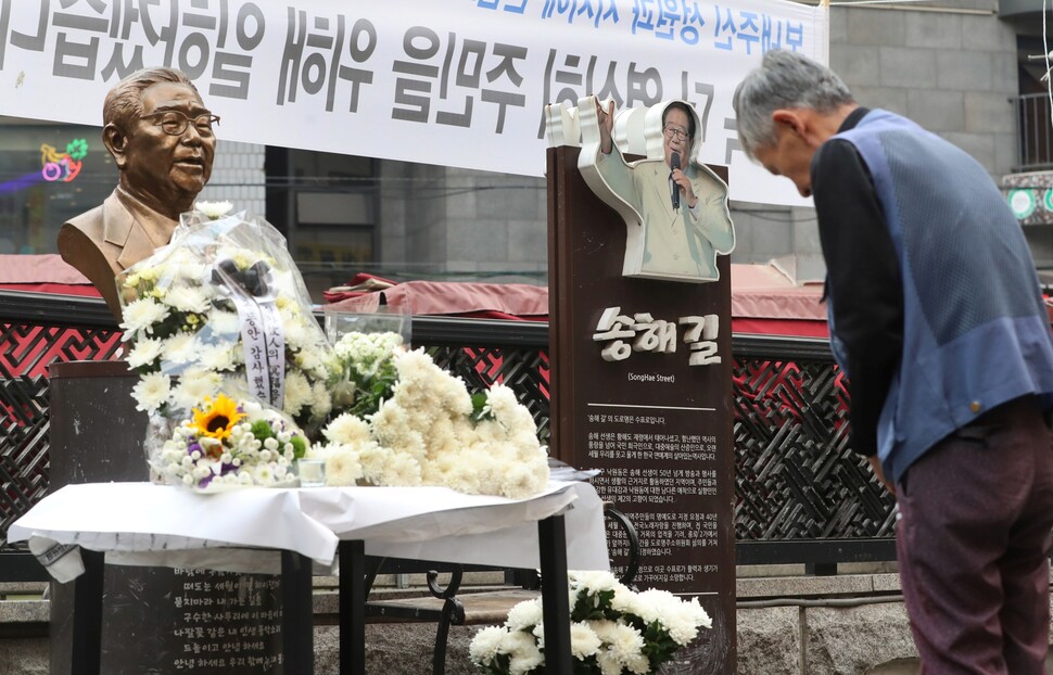 국민 엠시(MC) 송해가 향년 95로 별세한 2022년 6월8일, 서울 종로구 ‘송해길’을 찾은 시민들이 고인의 동상 앞에서 명복을 빌고 있다. 한겨레 신소영 기자