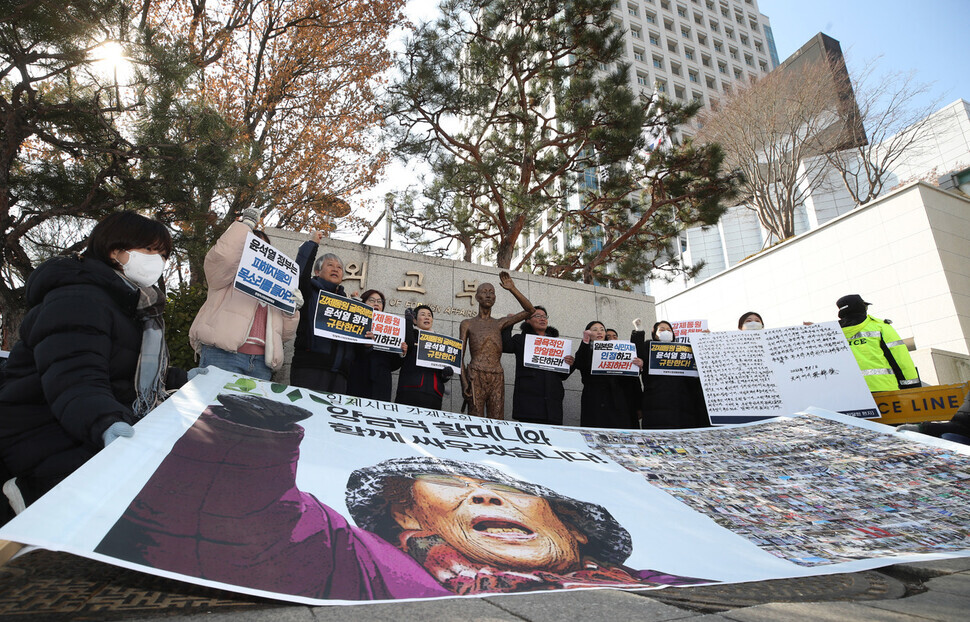 Members of Joint Action for Historical Justice and Peaceful Korea-Japan Relations hold a press conference outside the Ministry of Foreign Affairs on Feb. 22 to condemn the South Korean government for negotiating with Tokyo on compensation for victims of forced labor mobilization during the Japanese occupation, holding up a banner with a photo of Yang Geum-deok, a victim of forced mobilization. (Shin So-young/The Hankyoreh)