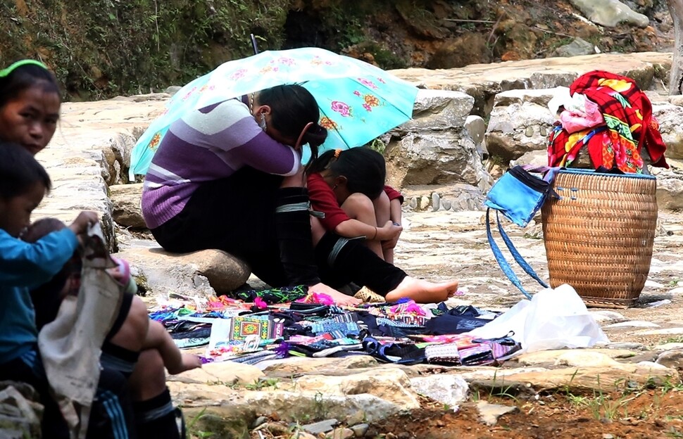 사파 지역의 유명한 트레킹 코스인 깟깟 마을에서 물건을 팔던 아이가 더위를 피하기 위한 양산을 엄마와 함께 쓴 채 잠이 들었다. 
