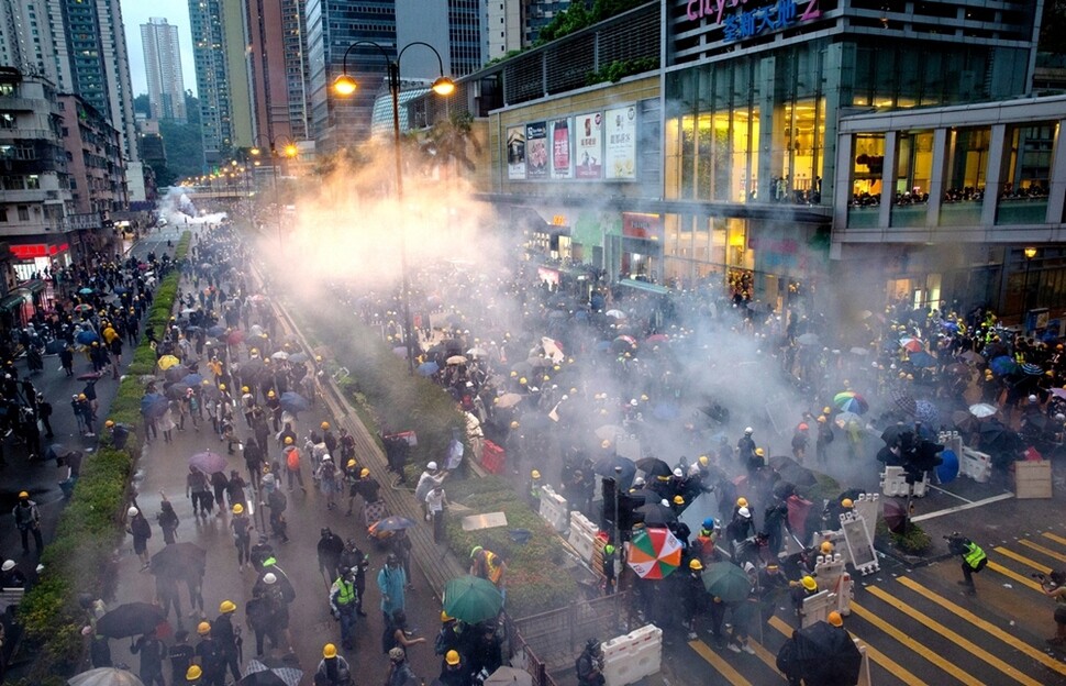 주말 집회가 계속된 8월25일 저녁 췬완 쇼핑몰 주변에서 경찰이 거리를 가득 메운 시민들에게 최루탄을 쏘고 있다.