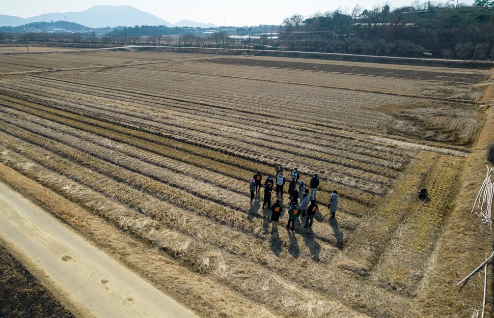 기후위기비상행동 회원들이 생태 유기농 지역인 충남 홍성 홍동마을 들녘에서 기후위기 시대 농업에 대한 지역주민의 설명을 듣고 있다.