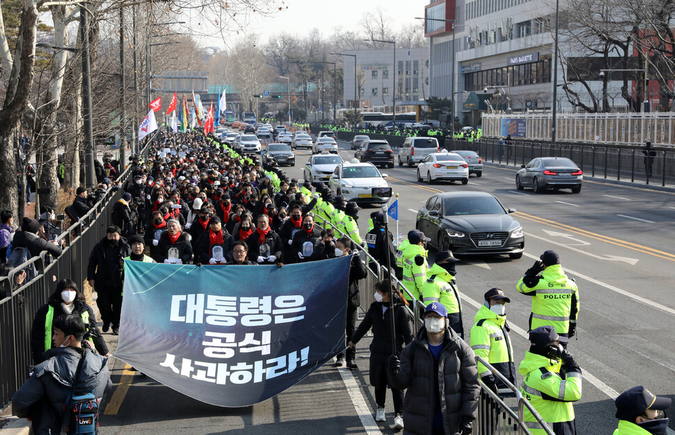 추모행진 참가자들이 서울 용산구 대통령실 앞 도로를 지나며 윤석열 대통령의 공식 사과를 요구하고 있다.