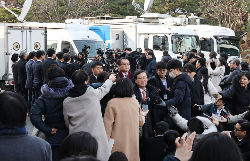 윤석열 대통령의 탄핵심판 첫 변론기일인 2025년 1월14일 오후 탄핵소추단(왼쪽 등지고 선 이들)과 윤갑근 변호사(가운데 발언하는 이) 등 윤석열 대통령 변호인단이 서울 종로구 헌법재판소에서 변론을 마친 뒤 각각 입장을 밝히고 있다. 한겨레 신소영 기자 