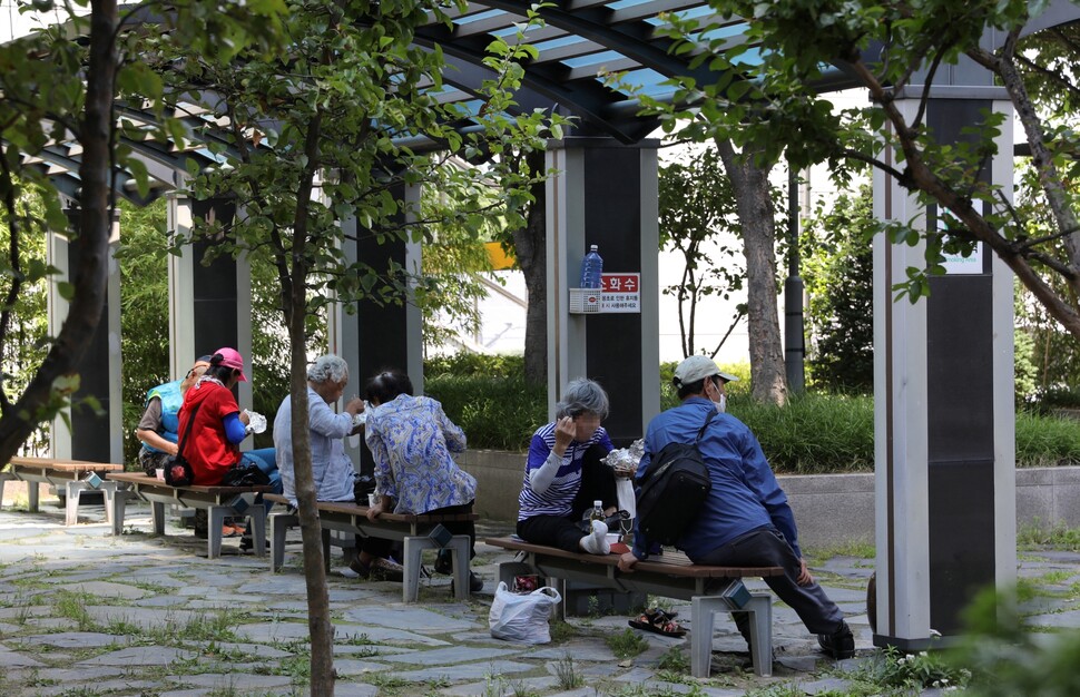 어르신들이 대전역 동광장 옆 공원 벤치로 자리를 옮겨 식사하고 있다.