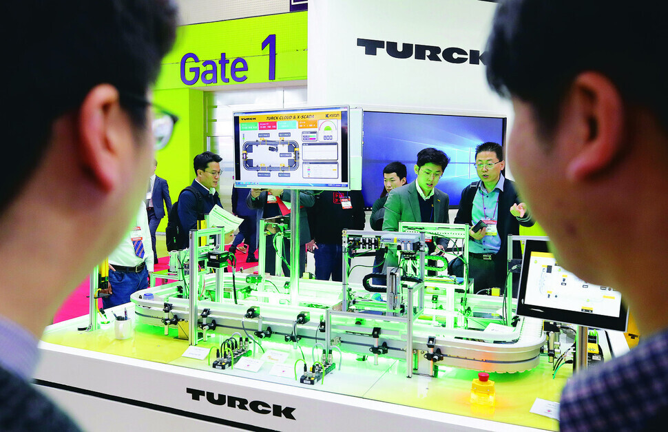 Visitors to the Smart Factory Expo held at Coex in Gangnam, Seoul, in March 2019 peer at a display. (Yonhap)