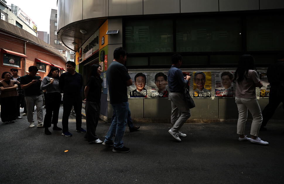 제21대 대통령 선거 사전투표 첫날인 2025년 5월29일 오전 사전투표소가 설치된 서울 중구 소공동주민센터 들머리에서 유권자들이 벽보를 보고 있다. 이종근 선임기자