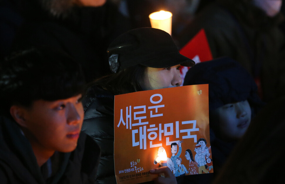 Citizens watch a performance at the seventh weekly candlelight demonstration in Seoul on Dec. 10