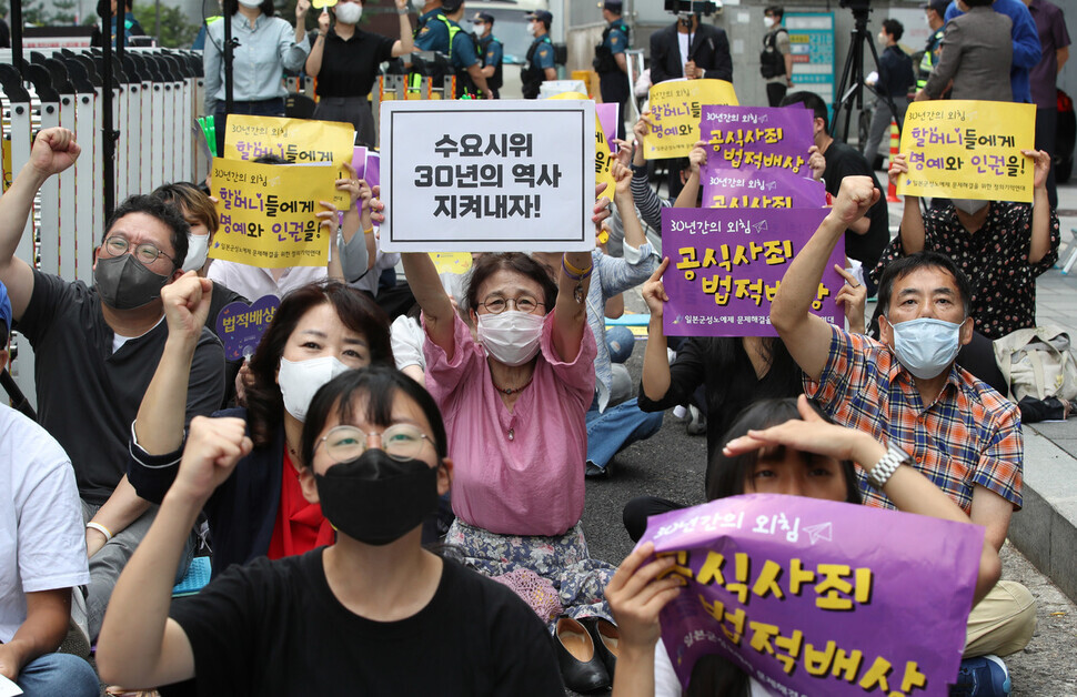 Participants in the 1,561st Wednesday Demonstration, held on Sept. 14, hold up signs and chant for the issue of Japan’s wartime sexual slavery to be resolved. (Shin So-young/The Hankyoreh)