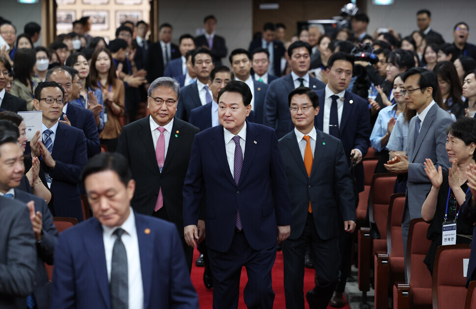 President Yoon Suk-yeol enters an event celebrating the 60th anniversary of the Korean National Diplomatic Academy flanked by Foreign Minister Park Jin (left) and the academy’s chancellor, Park Cheol-hee. (Yonhap)