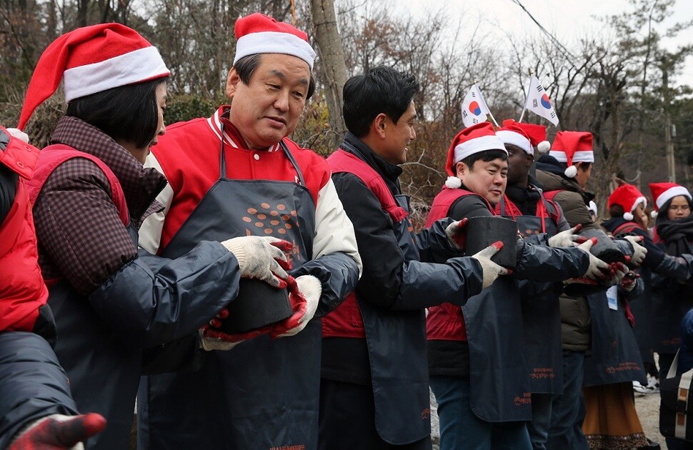 Saenuri Party leader Kim Moo-sung during a charcoal donation activity with foreign exchange students in the Samseong neighborhood of Seoul’s Gwanak district