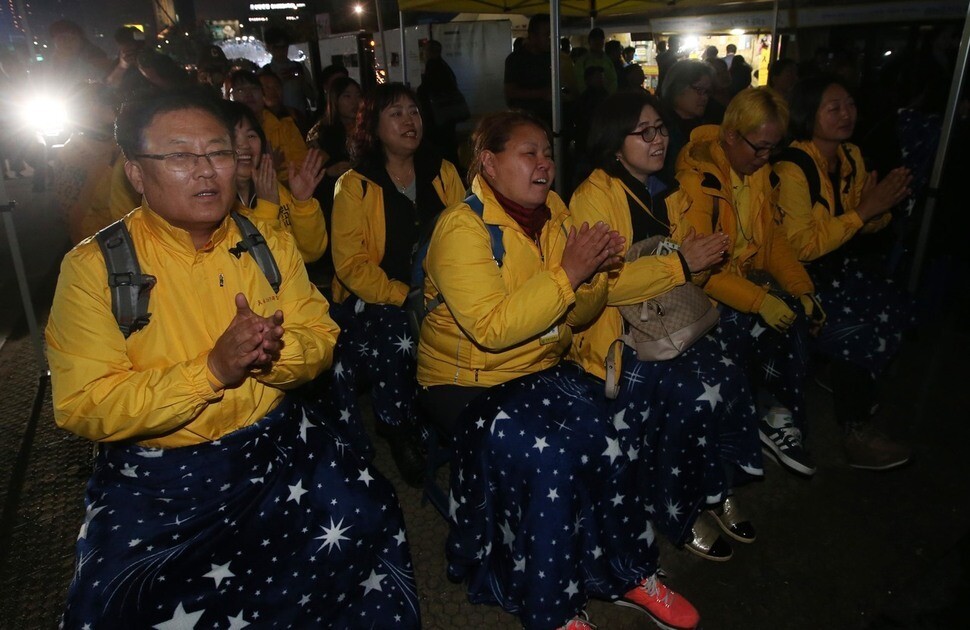Families of victims of the Sewol ferry sinking watch the results of the presidential election