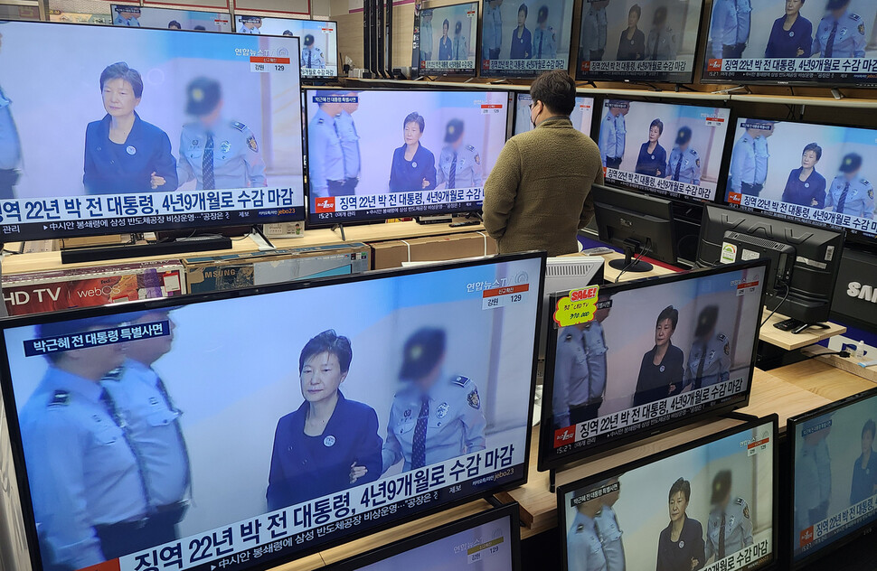 24일 오후 서울 용산구 용산전자상가에서 시민이 박근혜 전 대통령 특별사면 관련 뉴스를 시청하고 있다. 연합뉴스