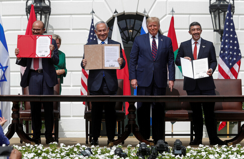 Bahrain’s Foreign Minister Abdullatif Al Zayani, Israeli Prime Minister Benjamin Netanyahu, and UAE Foreign Minister Abdullah bin Zayed pose with copies of the signed Abraham Accords alongside US President Donald Trump at the White House on Sept. 15, 2020. (Reuters/Yonhap)