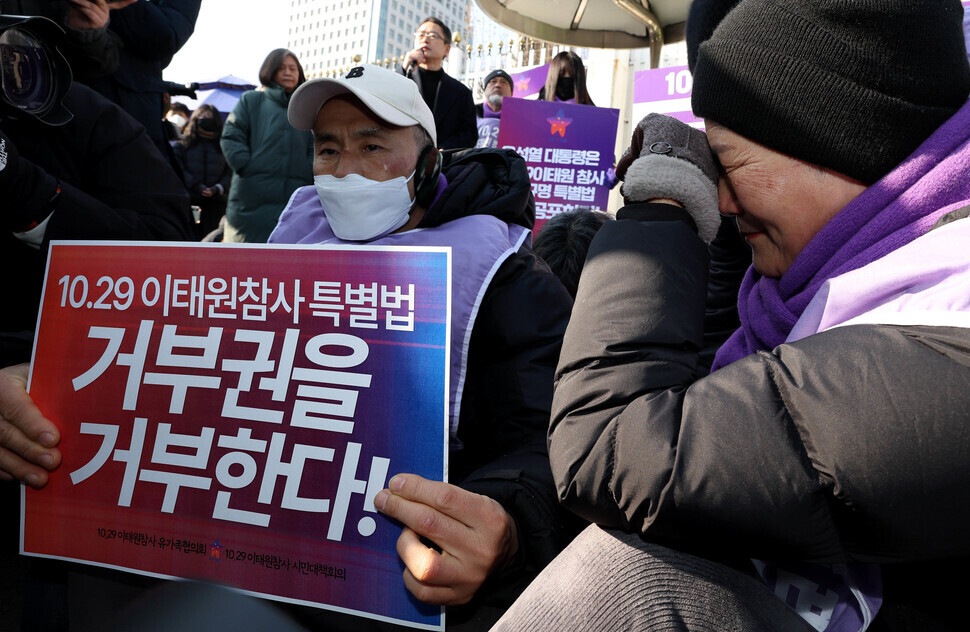 Caption 1-1: Families of those who were killed in the Oct. 29, 2022, Itaewon crowd crush break down into tears during a rally outside the central government complex in Seoul on Jan. 30 upon news breaking that the Cabinet had recommended that the president exercise his veto on a bill that would have mandated a special investigation into the disaster that killed 159. The sign being held reads: “We reject the rejection of the Itaewon disaster special act!” (Kim Jung-hyo/The Hankyoreh)