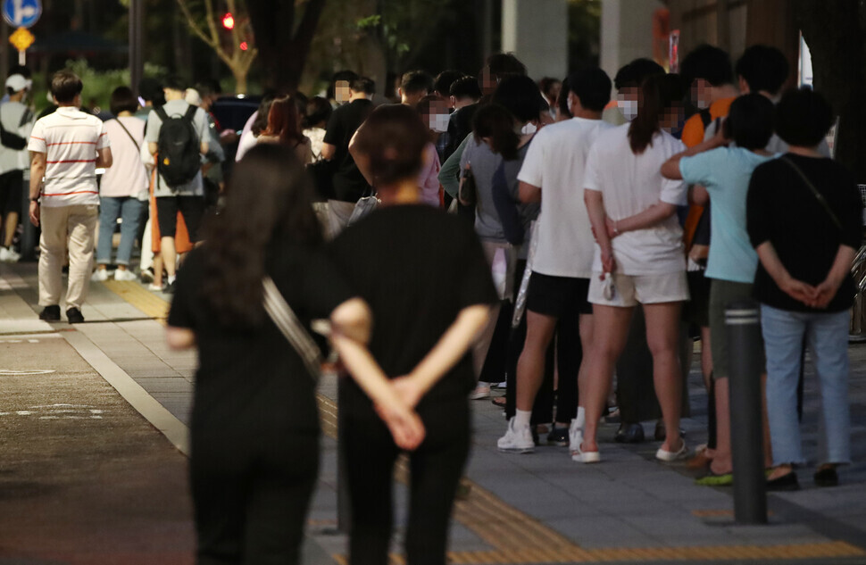 People wait in line at a nighttime temporary screening center in Seoul to get tested for COVID-19 on Wednesday. (Yonhap News)
