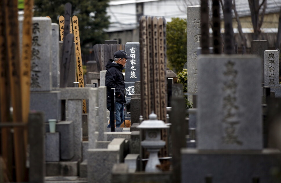 일본 도쿄의 묘지에서 한 남자가 묘비 사이를 걷고 있다. REUTERS