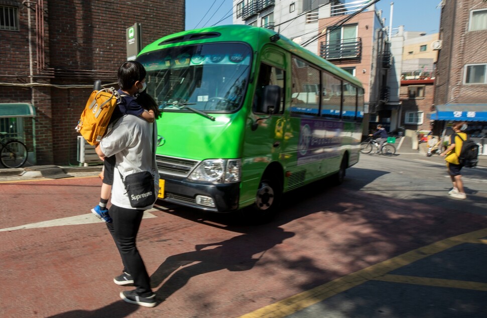 2022년 5월31일 서울 성동구에 사는 발달장애 아동 우진(가명)이가 엄마 품에 안겨 마을버스를 타러 가고 있다. 김진수 선임기자